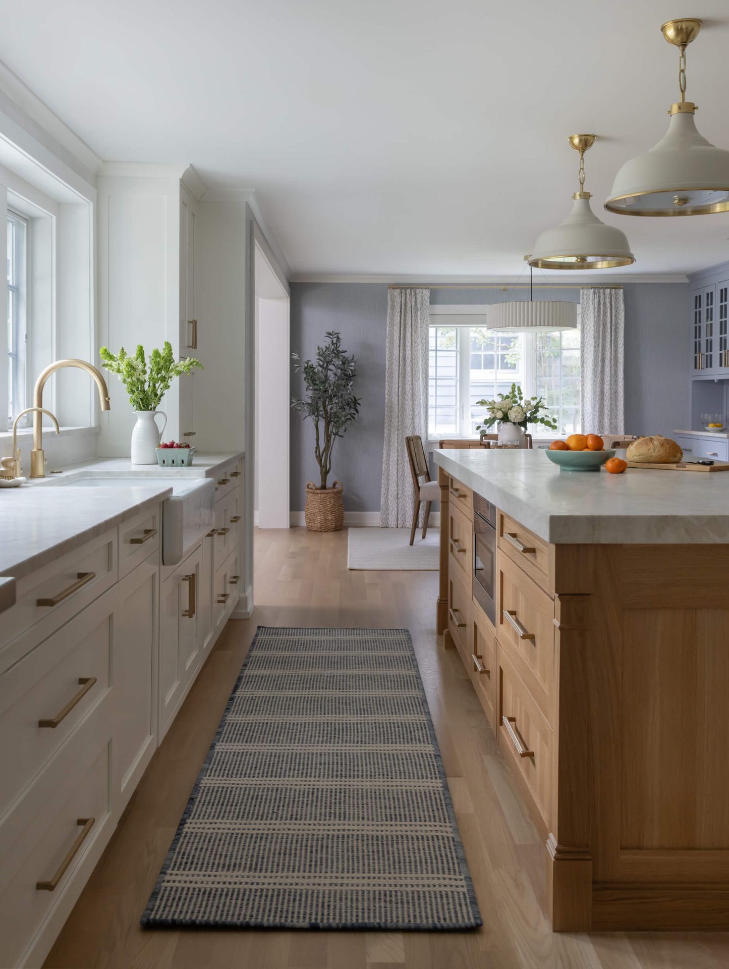 Bright kitchen with white oak island and brass pendants