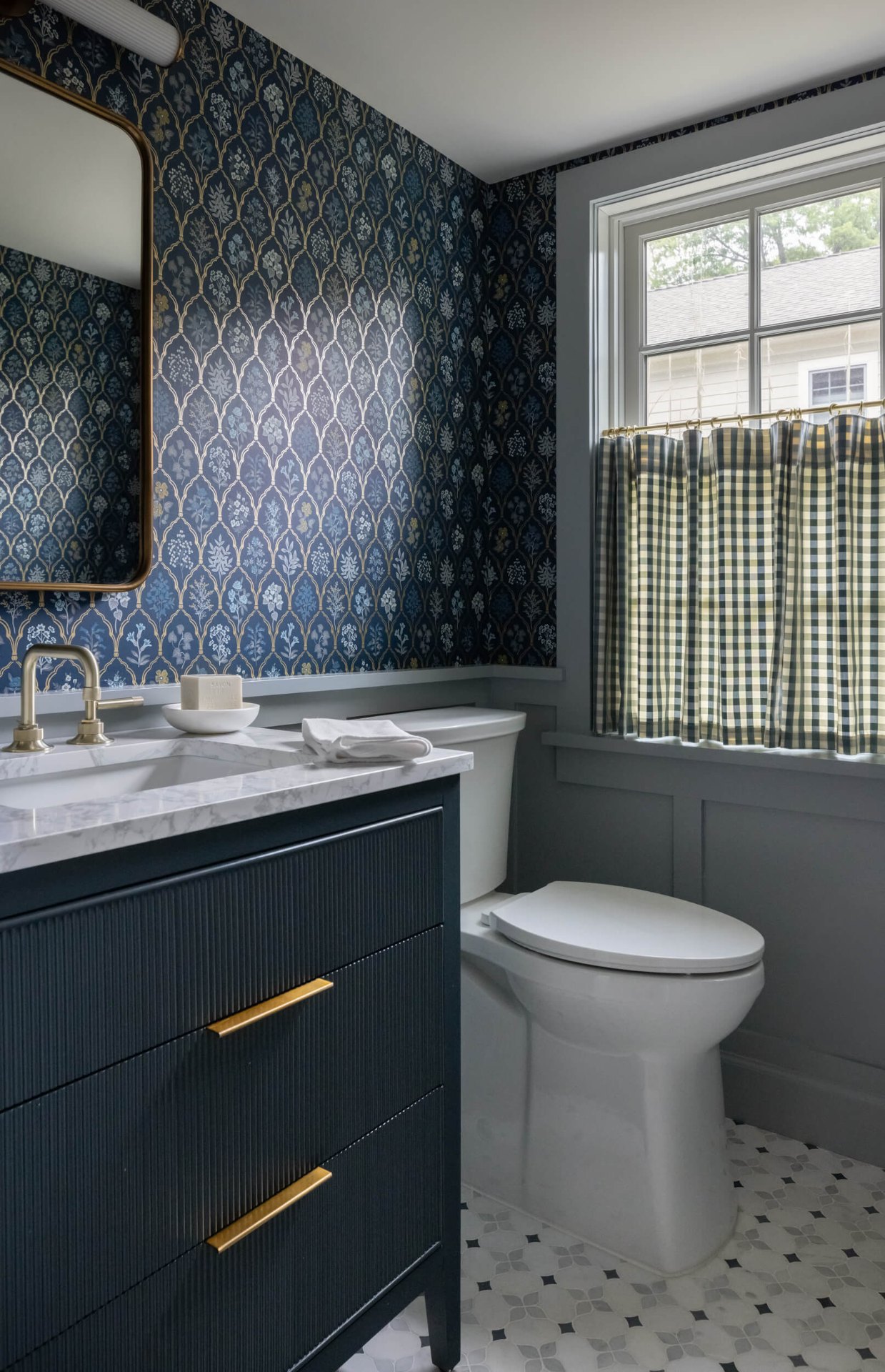 Powder room with blue floral wallpaper and gingham cafe curtains